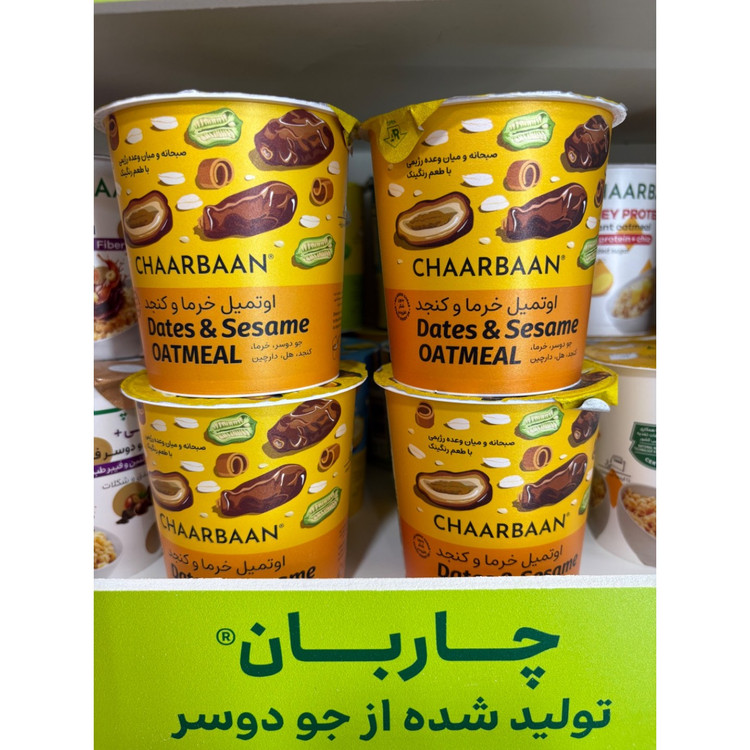 غلا صبحانه لیوانی حاوی تکه های خرما و کنجد